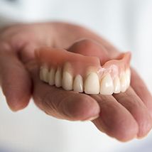 Close up of upper denture held in hand