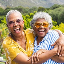 Two women embracing and smiling outside
