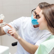 Tomball implant dentist showing patient a model mouth with implants