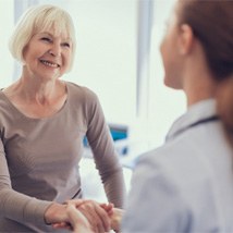 Smiling patient and dentist discussing the cost of dental implants in Tomball 