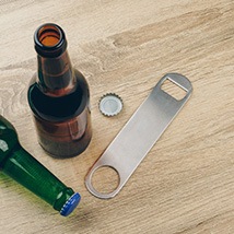 Bottle cap opener on wood table with two bottles