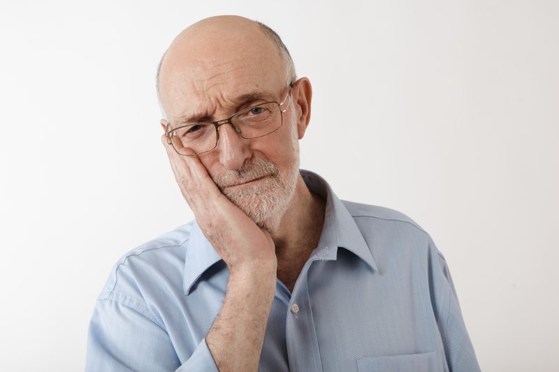 man holding jaw in pain needing root canal therapy