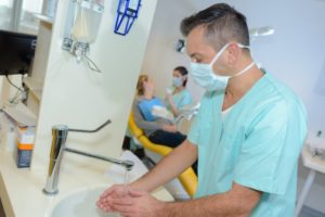 dentist in Tomball washing their hands before treating a patient
